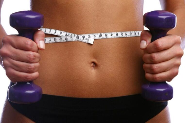 Fitness dumbbells in de handen van een fit meisje